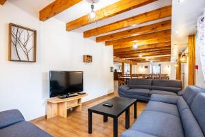 a living room with couches and a flat screen tv at Gite St Joseph gitesdes2vallees in Ventron