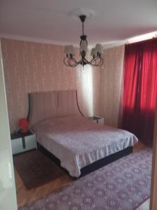 um quarto com uma cama e uma cortina vermelha em House in the garden. Sachkhere. em Ssatschcheri