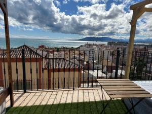 balkon z ławką i widokiem na ocean w obiekcie Rooms in Seafront Villa w Maladze