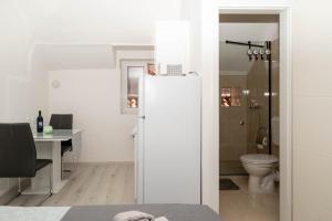 a white refrigerator in a room with a desk and a toilet at Guest house Ivona in Split +45 photos
