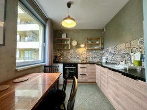 a kitchen with a wooden counter and a table at Apartament Szafranowy in Wrocław