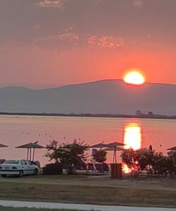 a sunset over the water with a car parked at Bella Vista Apartments Keramoti in Keramoti
