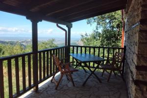 een tafel en stoelen op een balkon met uitzicht bij Picturesque double flat country house in Thrapsímion