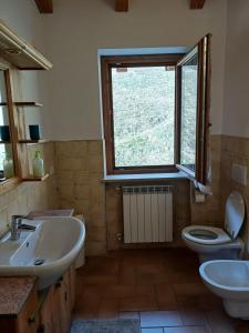 uma casa de banho com um lavatório, um WC e uma janela. em Agriturismo Trapletti em Serina
