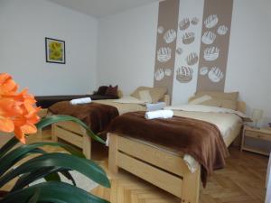 a bedroom with two beds and a plant at Pogácsás Apartman in Tokaj +141 photos