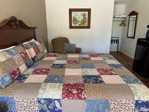 a bedroom with a bed with a quilt on it at Sunset Inn and Suites in Fredericksburg