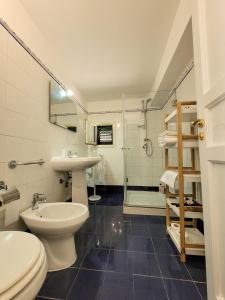 a bathroom with a toilet and a sink and a shower at B&B Loft Famiglia Arezzo in Ragusa