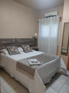 a bedroom with a large bed and a window at Mirante Hotel in Santa Vitória do Palmar