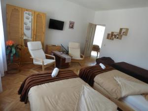 a bedroom with two beds and a desk and chairs at Pogácsás Apartman in Tokaj