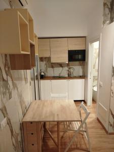 una pequeña cocina con mesa de madera y nevera. en B&B Confort en Reggio Calabria