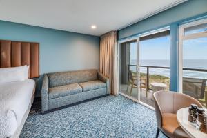 a bedroom with a bed and a couch and a balcony at The Whaler in Newport