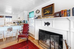 a living room with a fireplace and a red chair at Mountain Vista - Main House in Hesperus