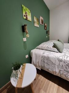 a bedroom with a bed and a white table and a table at Au Doux Refuge in Le Lambert