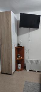 a room with a tv on the wall and a cabinet at Smeštaj Vrhovac in Vrdnik +55 photos