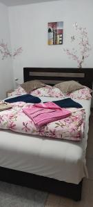 un letto con coperte rosa in una camera da letto di Smeštaj Vrhovac a Vrdnik