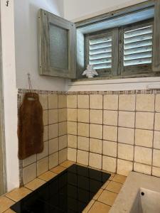 a tiled bathroom with a sink and a window at La Casetta - Typical Guest House in Fasano