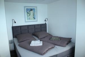 a bed with two pillows and two towels on it at Harzidyll-Meinecke in Blankenburg