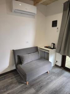 a gray couch in a room with a window at Campeggio Gianna Golfo dei Poeti in Lerici