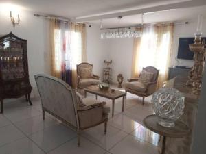 a living room with chairs and a couch and a table at Cozy Villa in Le Moule in Le Moule
