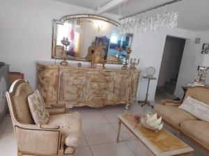 a living room with a large wooden dresser with a mirror at Cozy Villa in Le Moule in Le Moule