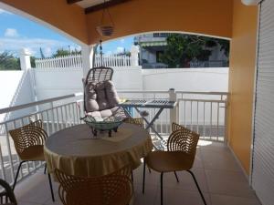 a patio with a table and chairs on a balcony at Cozy Villa in Le Moule in Le Moule