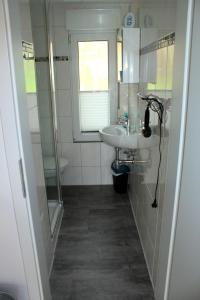 a white bathroom with a sink and a shower at Harzidyll-Meinecke in Blankenburg