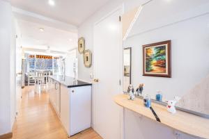 a kitchen and dining room with white walls and wood floors at Albatros 2-6 Estudio Levante Beach in Benidorm