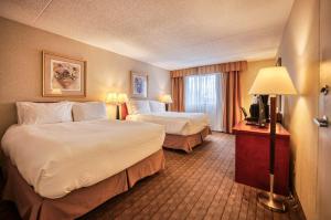 a hotel room with two beds and a television at Amenida Residences, Calgary in Calgary