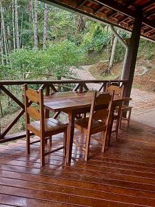 a wooden table and chairs on a wooden deck at Casa Araucária in Visconde De Maua