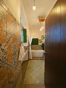 a bathroom with a tub and a sink and a door at Hotel Muchá in Quetzaltenango