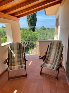 Duas cadeiras sentadas num alpendre com vista em Villa Raffaella em Selvatelle