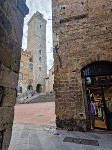 a person standing in a store in front of a castle at Appartamento Sotto le Torri in San Gimignano +7 photos