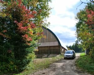 a car is parked in front of a barn at Meadowlark Cabin #5 in Maynooth