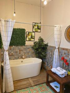 y baño con bañera y mesa. en Hotel Muchá en Quetzaltenango