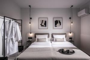 una camera da letto con due letti e un accappatoio sul letto di Icos City 1 a Hersonissos Altre 24 foto