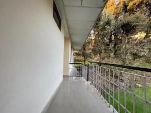 un balcón de una casa con una valla en The Lake Cottage by VRB Hotels en Dharamshala
