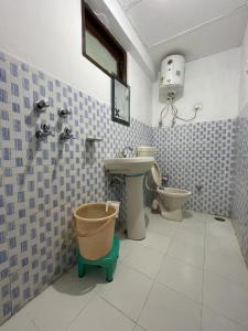 ein Bad mit einem Waschbecken und einem WC in der Unterkunft The Lake Cottage by VRB Hotels in Dharamshala