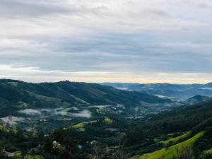 a view of a valley with fog in the hills at Casa do Vale in Serra Negra +10 photos