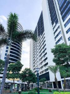 um grande edifício com palmeiras em frente em Linda vista al río. Seguridad y Parqueo em Guayaquil