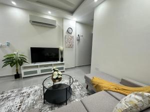 a living room with a couch and a tv at Muscat sand apartments in Muscat