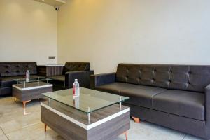 a waiting room with leather couches and tables at Super Capital O Poona Royal in Chinchwad