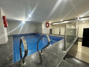 a swimming pool with two metal handles in a building at Muscat sand apartments in Muscat