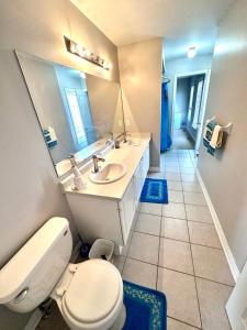 a bathroom with a toilet and a sink and a mirror at Home with Nance in Oshawa