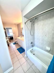 a bathroom with a white tub and a shower at Home with Nance in Oshawa