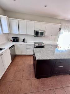 a kitchen with white cabinets and a counter top at Home with Nance in Oshawa