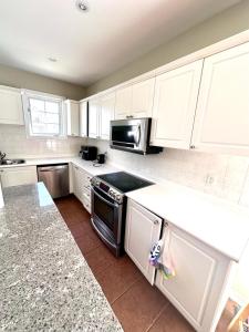 a kitchen with white cabinets and a stove top oven at Home with Nance in Oshawa