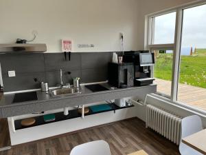 a kitchen with a sink and a microwave at Starlight Camping Pods in Hvolsvöllur