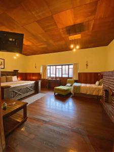 Habitación grande con 2 camas y sofá en Hotel Muchá en Quetzaltenango