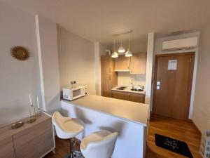 a kitchen with a counter with two chairs and a microwave at Encanto Comillas in Comillas