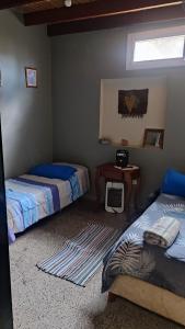 een slaapkamer met 2 bedden, een tafel en een raam bij Casa Manipa -3 dormitorios in Cafayate